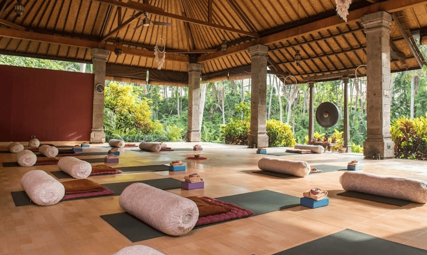 wooden yoga studio filled with matts and rugs 