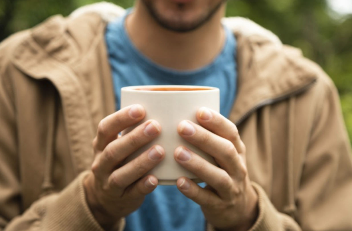 man holding cup of coffee 